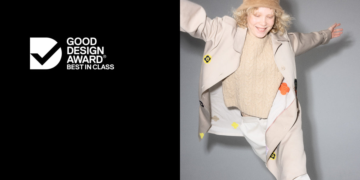 Woman in a trench coat covered in colourful FabPatch repair patches, beside the Good Design Award Best in Class badge